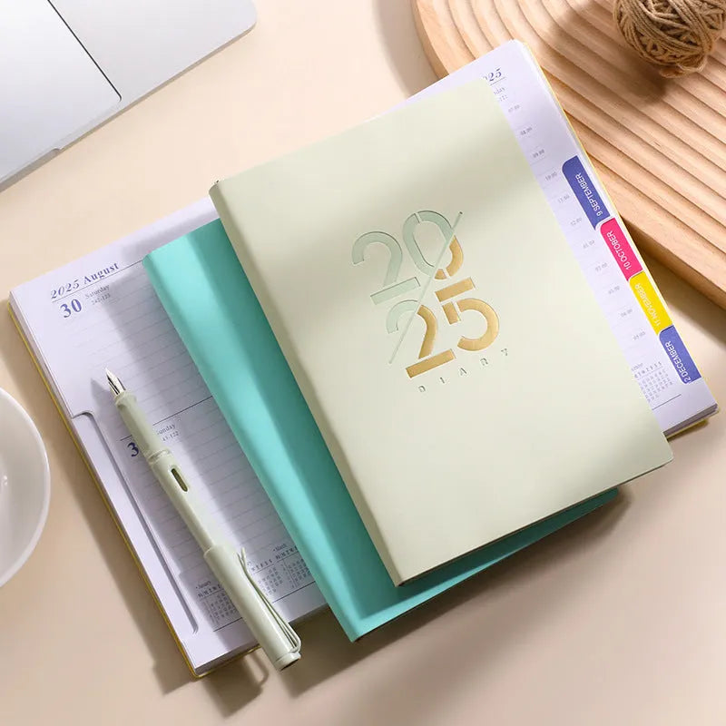 Soft faux leather A5 daily planner book open on a desk, showing Dorian paper pages and available colour variants.