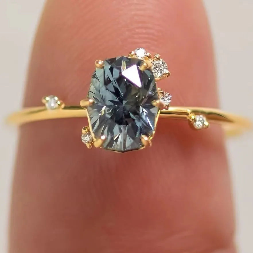 Gold electroplated alloy flower-shaped ring with inlaid green zircon stones on a white background.