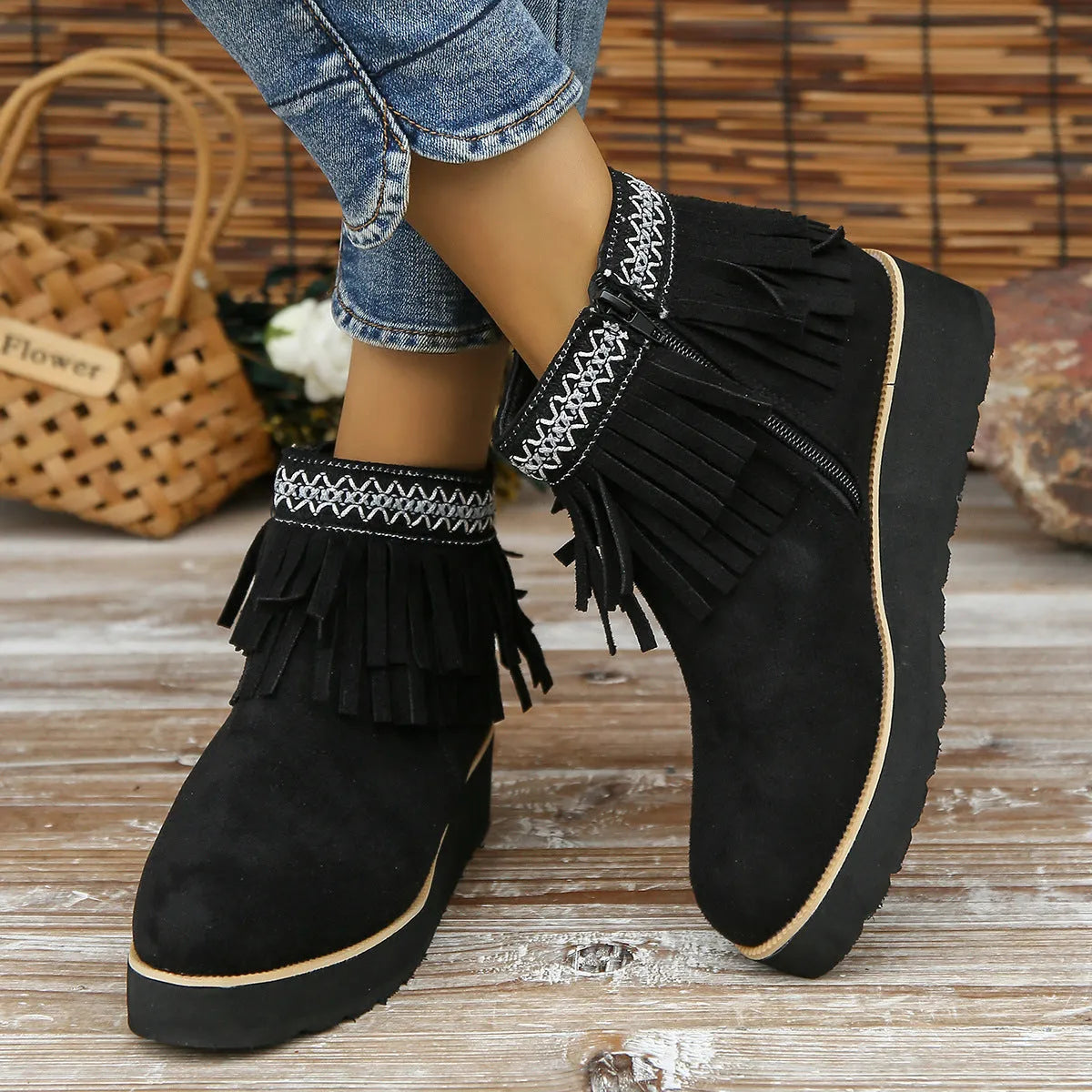 Women's suede ankle boot with wedge heel, side zipper, and tassel detail in dark brown.