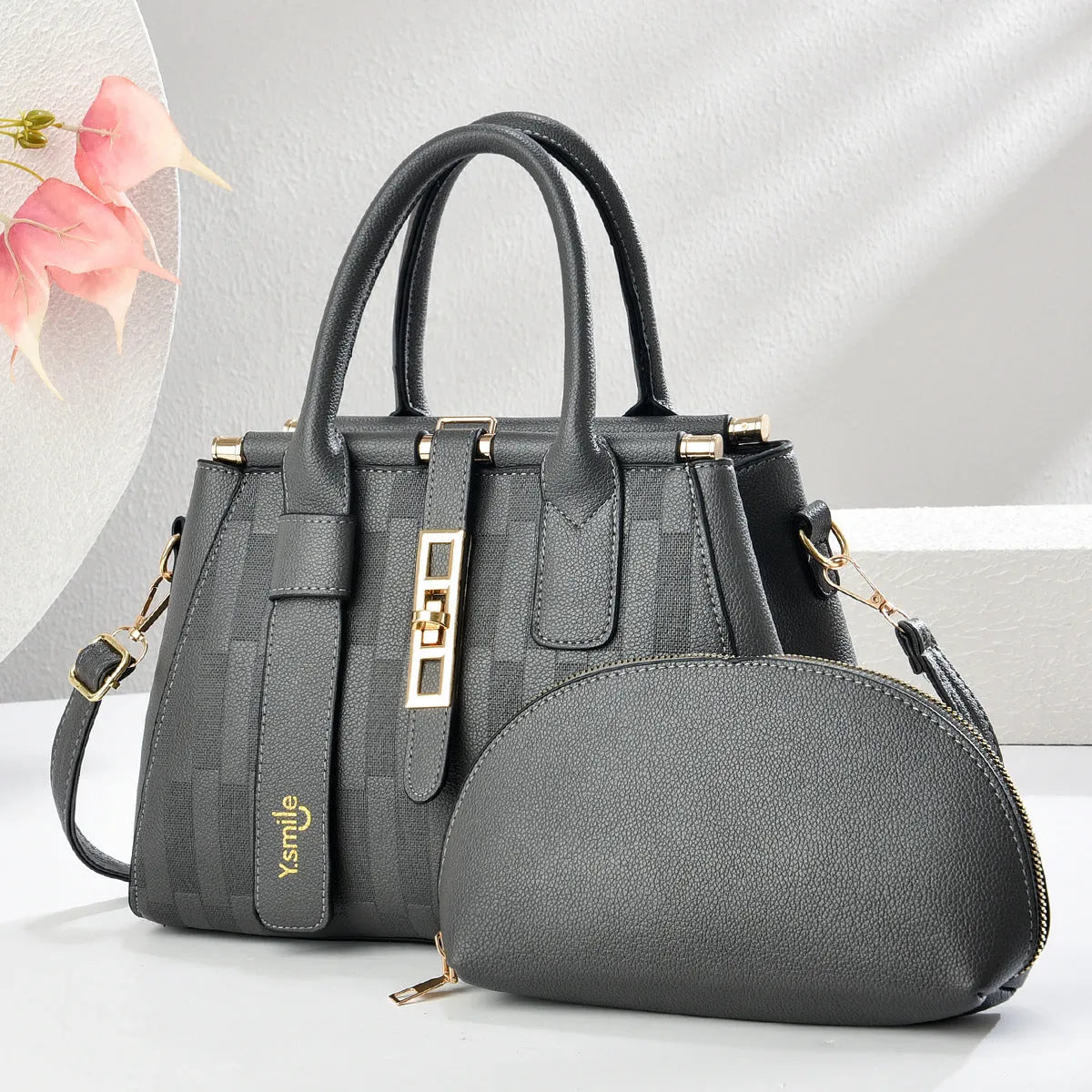A pair of round black and light khaki PU leather crossbody bags with adjustable straps.