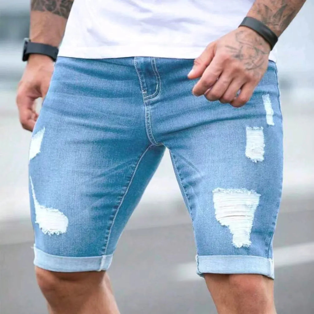 Sky blue men's denim shorts with a multi-hole distressed design and a straight leg.