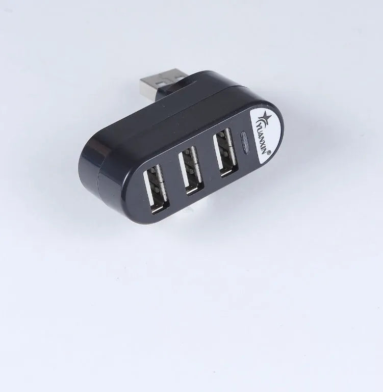Black and white 4-port USB 2.0 splitter hub shown next to a laptop