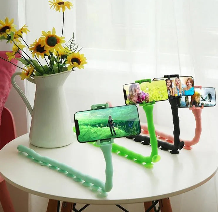 Flexible worm design mobile phone holder with suction cup mounted on desktop showing 360-degree rotation