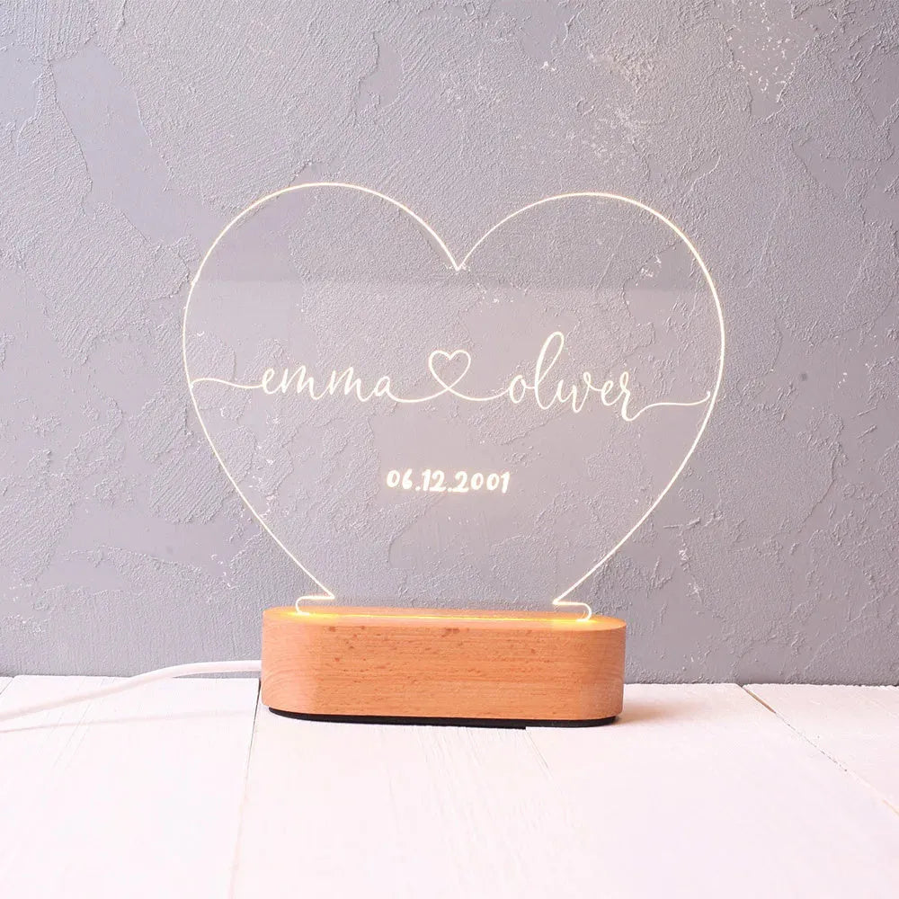 Custom transparent acrylic night light engraved with names, lit by LED base, dimensions 20cm by 11.5cm.