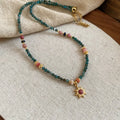French royal style sun necklace with freshwater pearls and a blue stone geometry pendant on a gold chain.