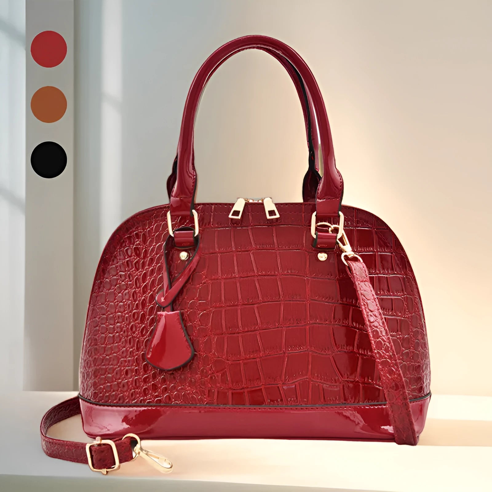 Large shiny PU crossbody shoulder bag in structured shell shape showing black, red, and brown colour options
