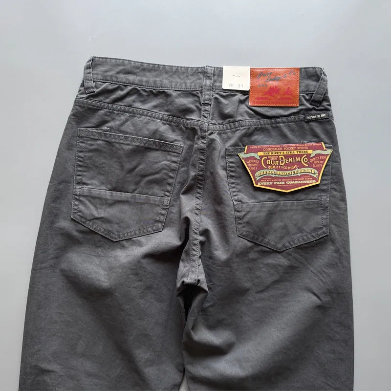 Men's grey straight-leg cotton casual trousers laid flat, showing mid-waist and inelastic design.