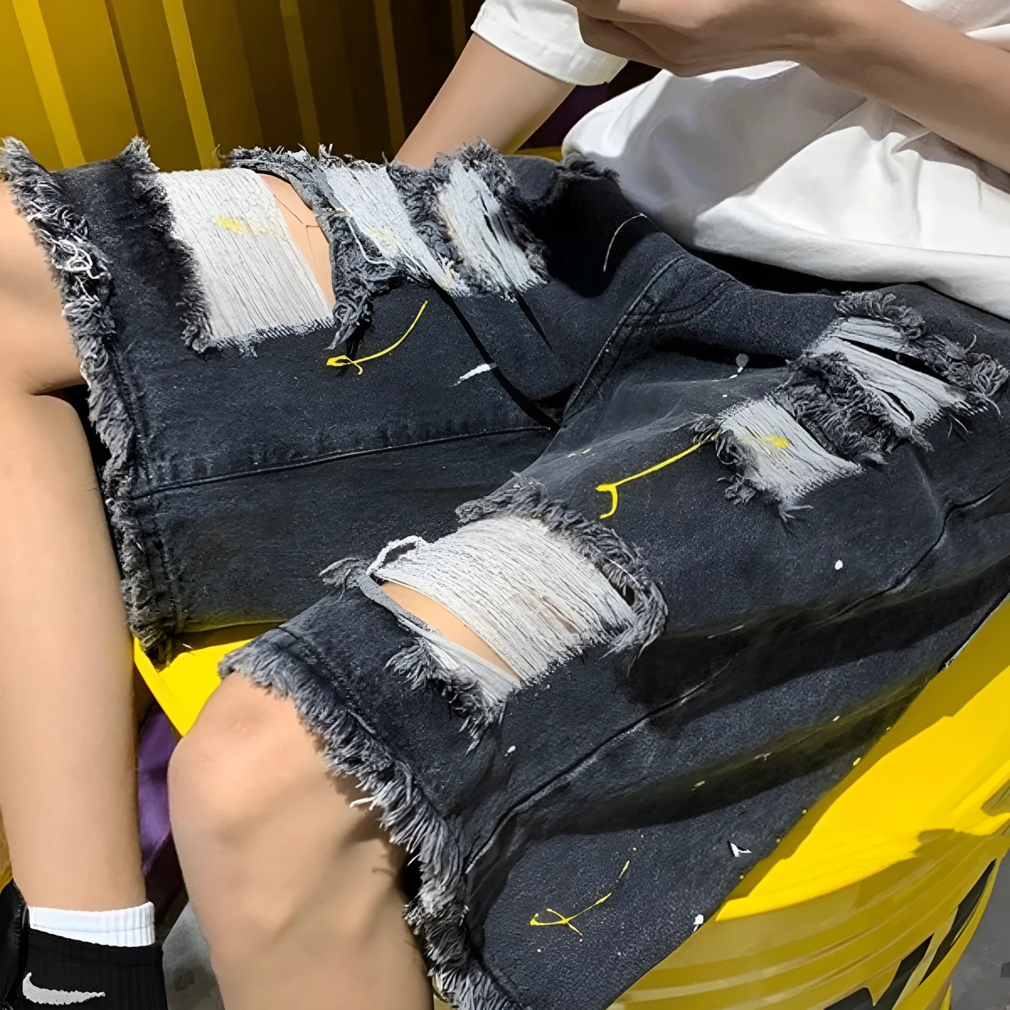 Men's loose fit water washed denim shorts with hole details in light blue, showing fifth pants length.