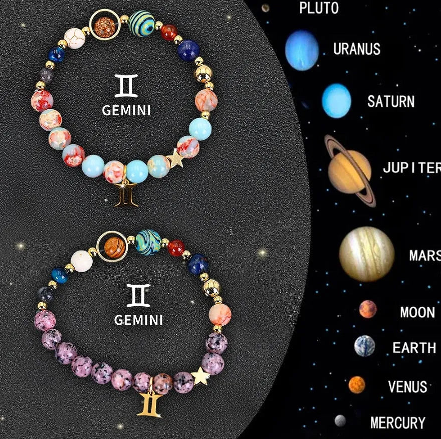 Set of twelve beaded bracelets with natural stone beads and sterling silver zodiac charms on a dark background.