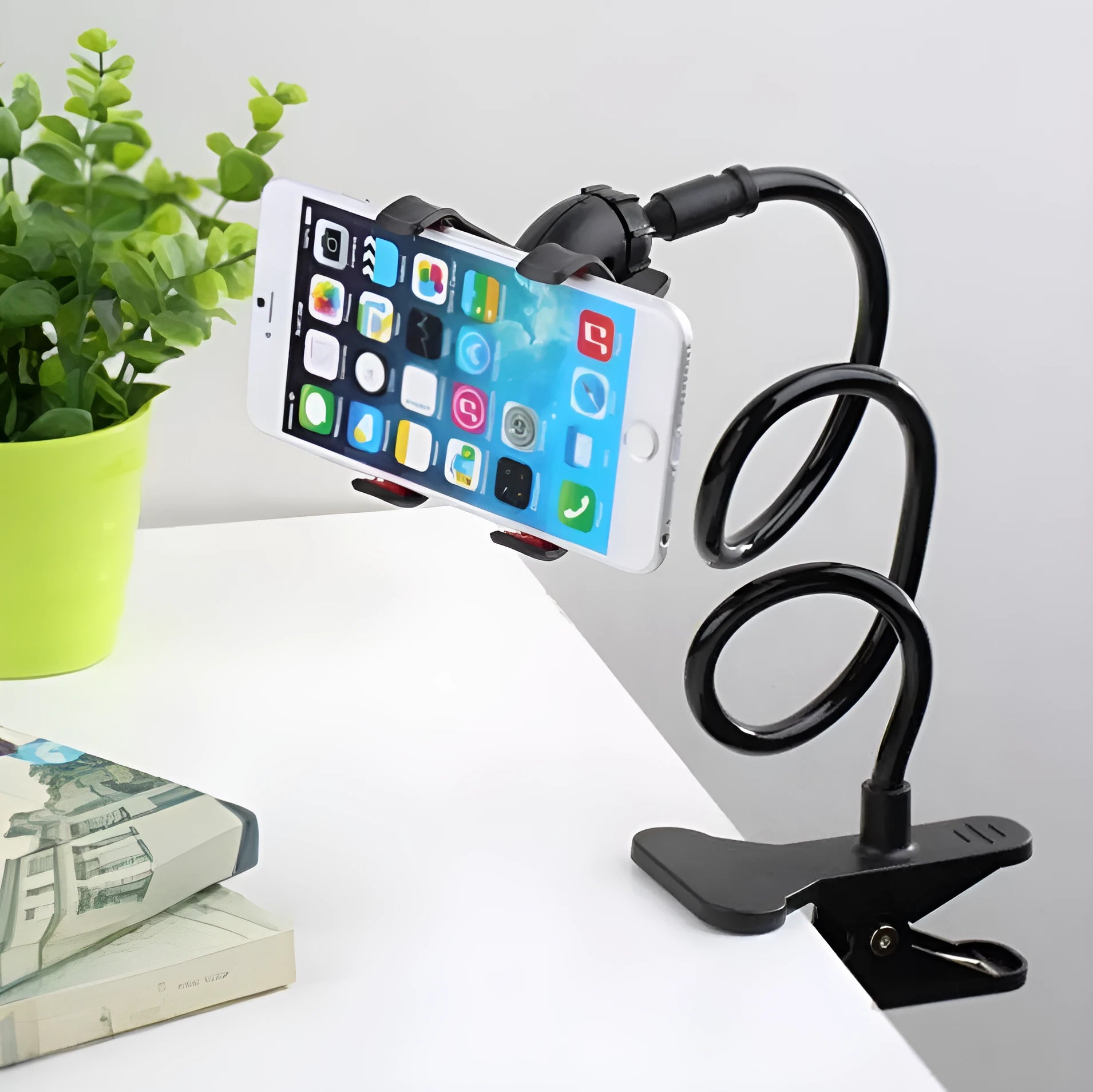 Black flexible arm phone holder with V-clip mounted on bed headboard holding smartphone