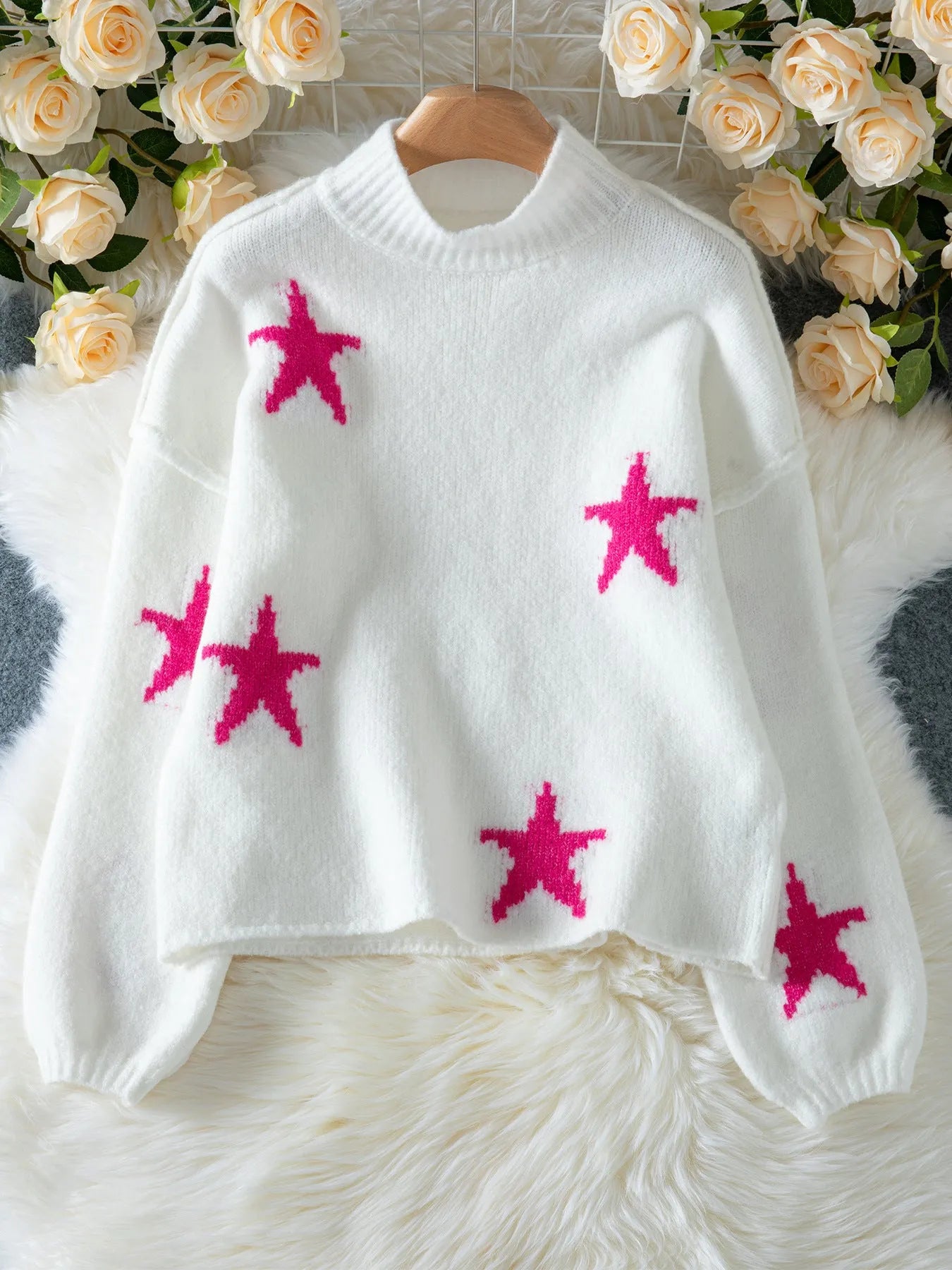 White women's loose turtleneck pullover with a black five-pointed star pattern on the front, made from thick polyester fabric.