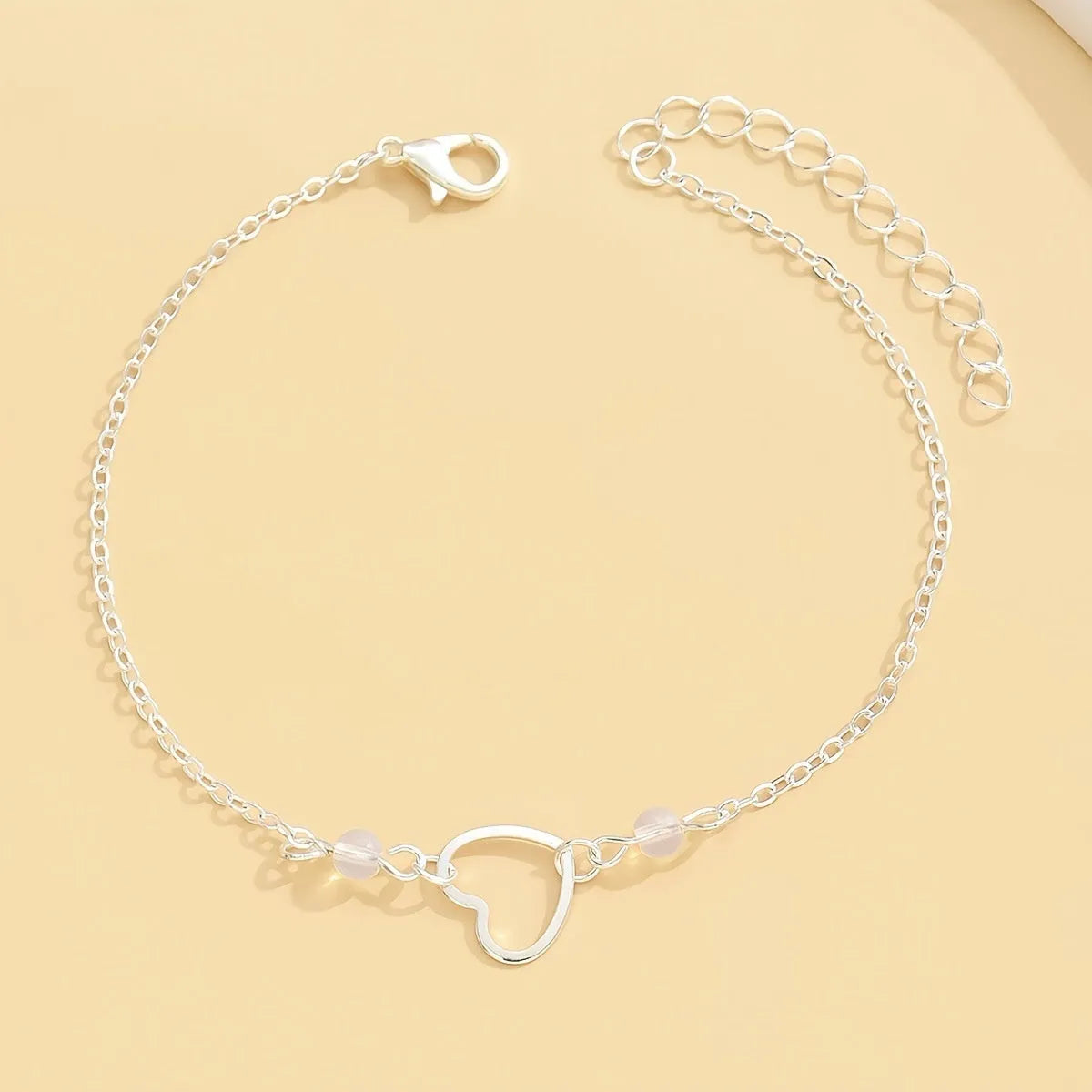 Gold and silver women's anklet with heart-shaped pendant charm and adjustable length