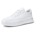 Women's white leather flat casual lace-up shoes on a neutral background.