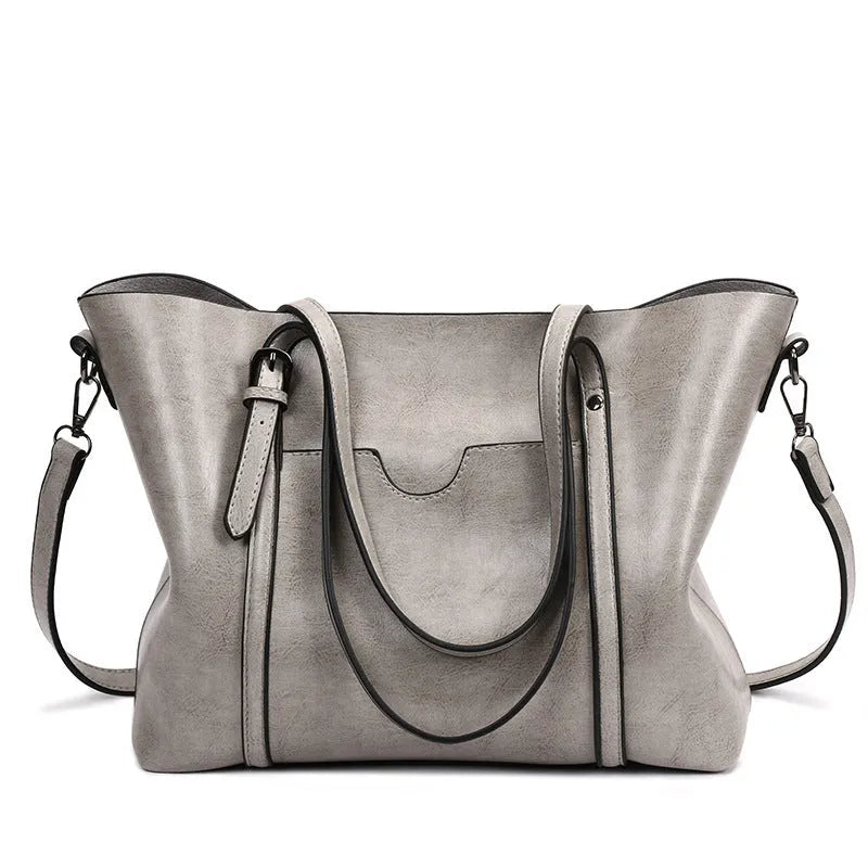 Retro-style brown PU messenger bag for women shown with shoulder strap, displaying its large main compartment.