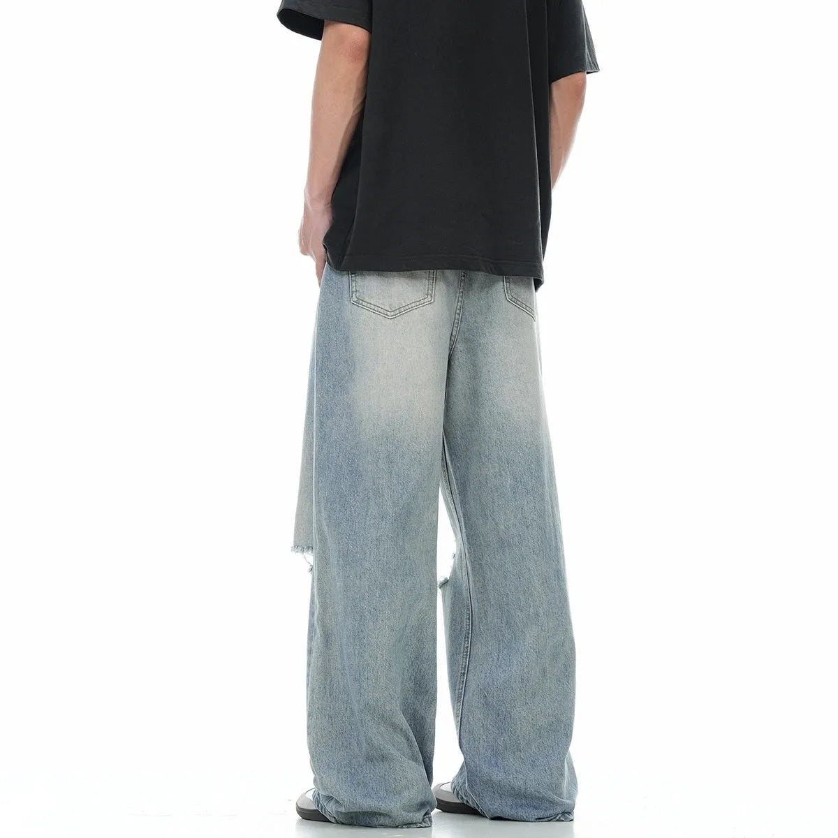 Blue men's straight-leg jeans with ripped detailing on the legs, showing a zipper fly.