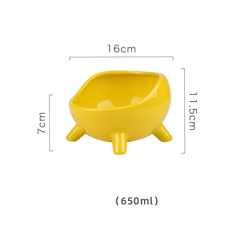 Green ceramic cat food bowl with four legs and rounded arc design on wooden floor