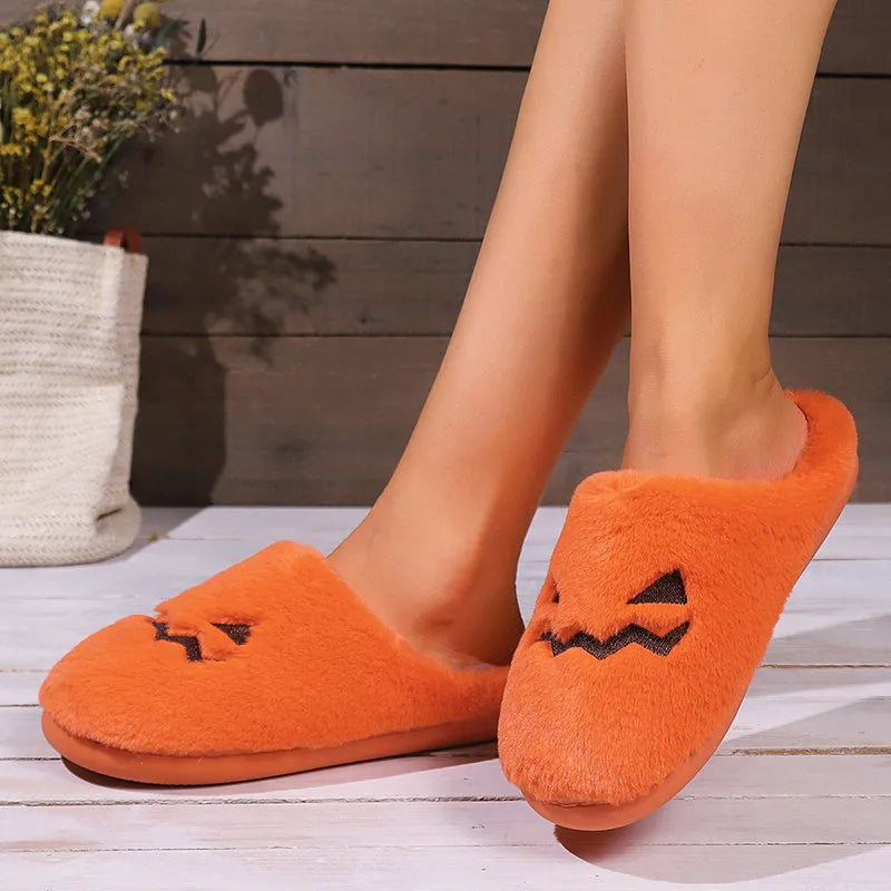 Orange pumpkin-themed plush slippers with a non-slip sole for indoor home wear.