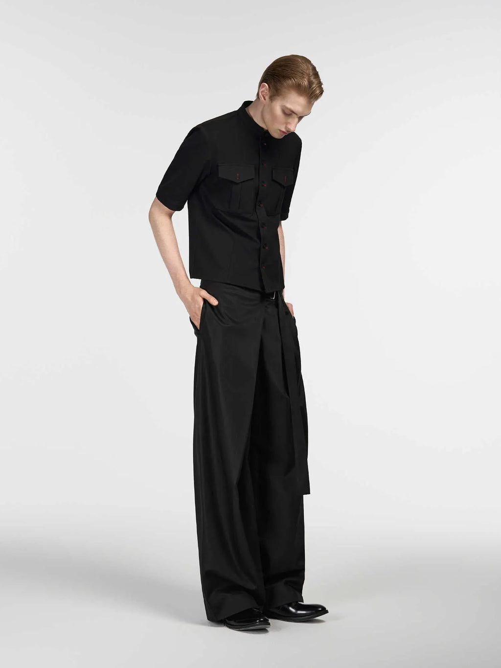 Black straight-leg trousers with a single pleat and adjustable waistband on a hanger