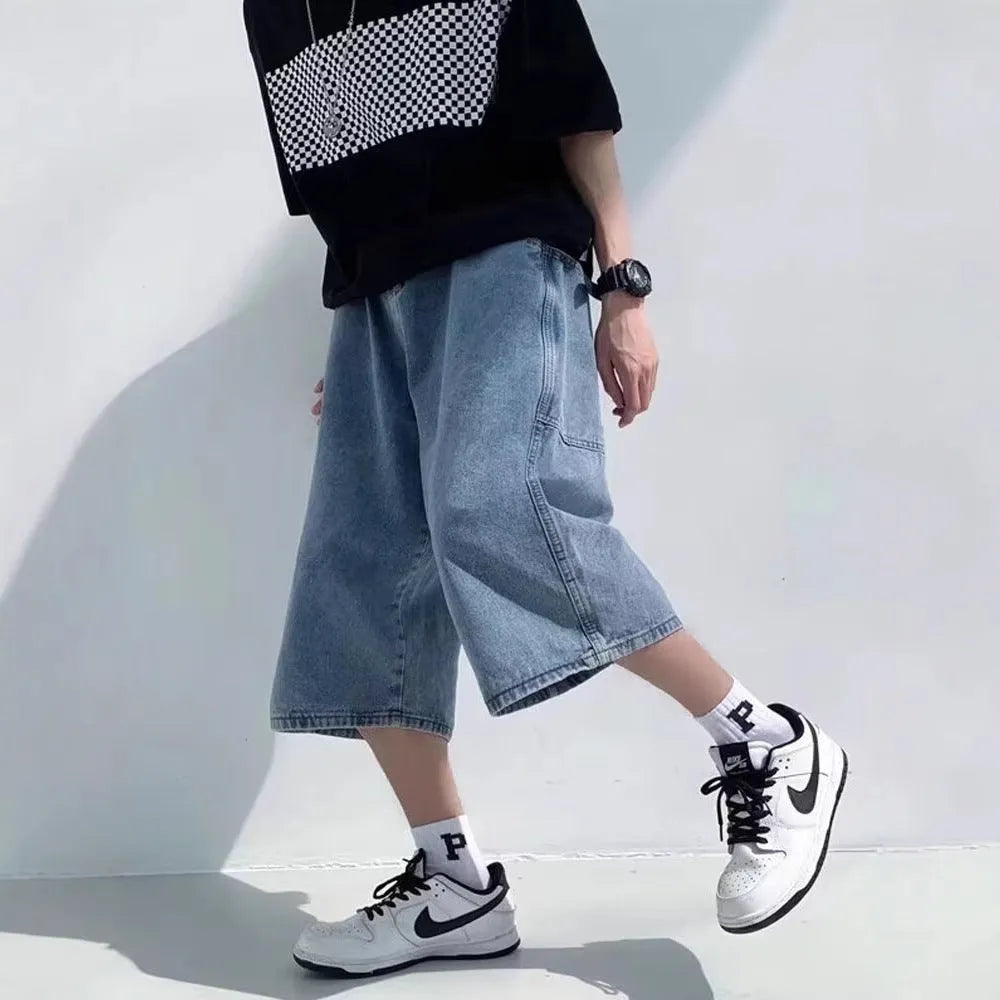 Man wearing blue washed denim shorts with a high waist, cropped leg, and straight cut.