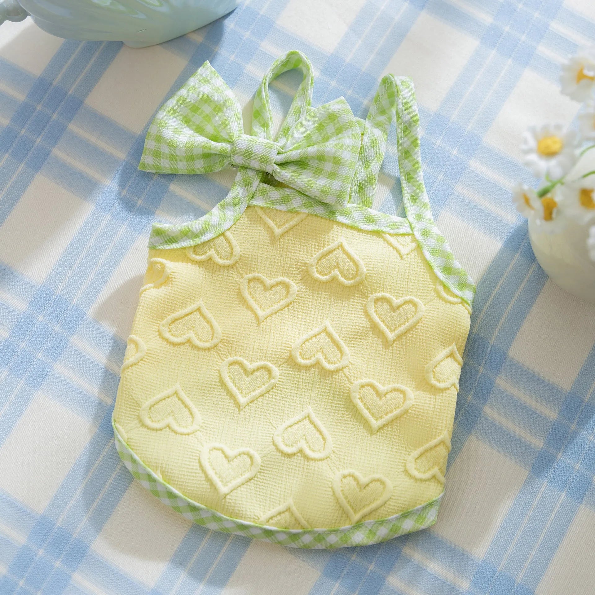 Small dog wearing heart bow suspenders vest in blue with elastic sides