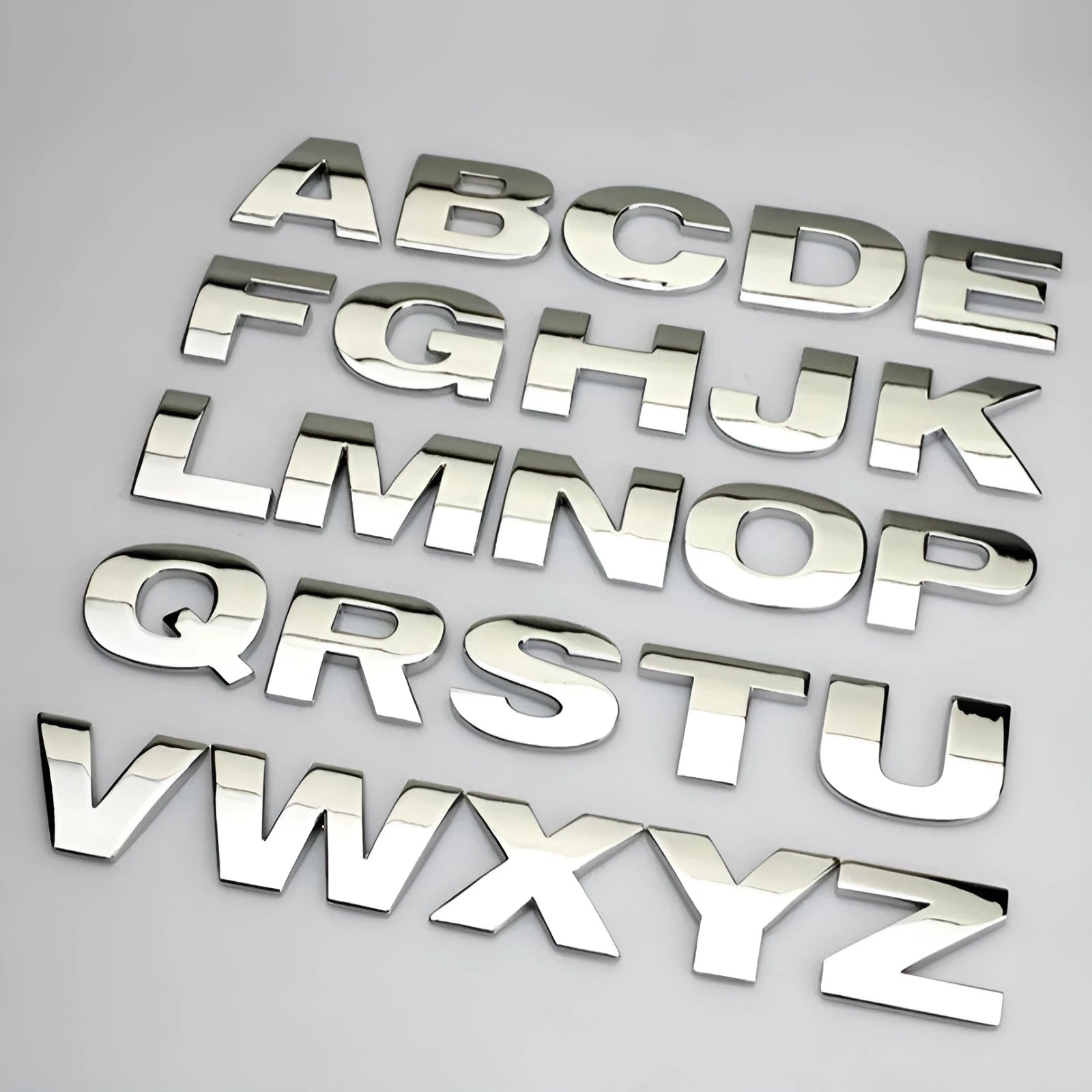 Close-up of a 3D metal zinc alloy letter 'A' car bumper sticker in silver finish.