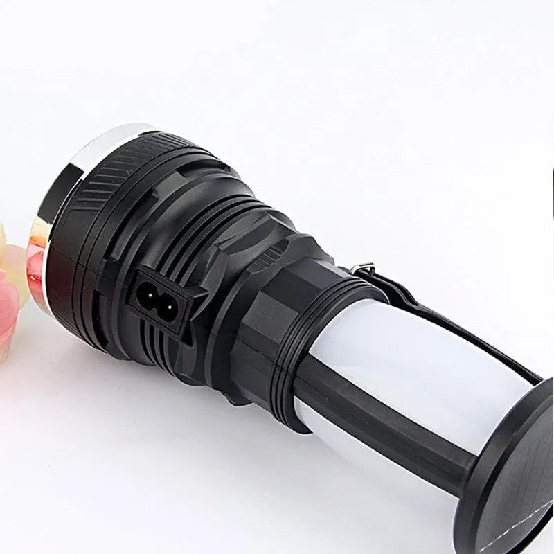Black solar-powered LED flashlight with USB charging port shown on a textured background.