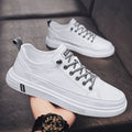 Men's white casual shoes with round toe and flat low heel on a plain background