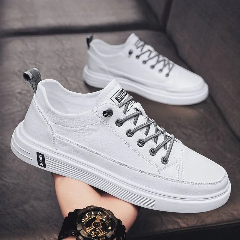 Men's white casual shoes with round toe and flat low heel on a plain background