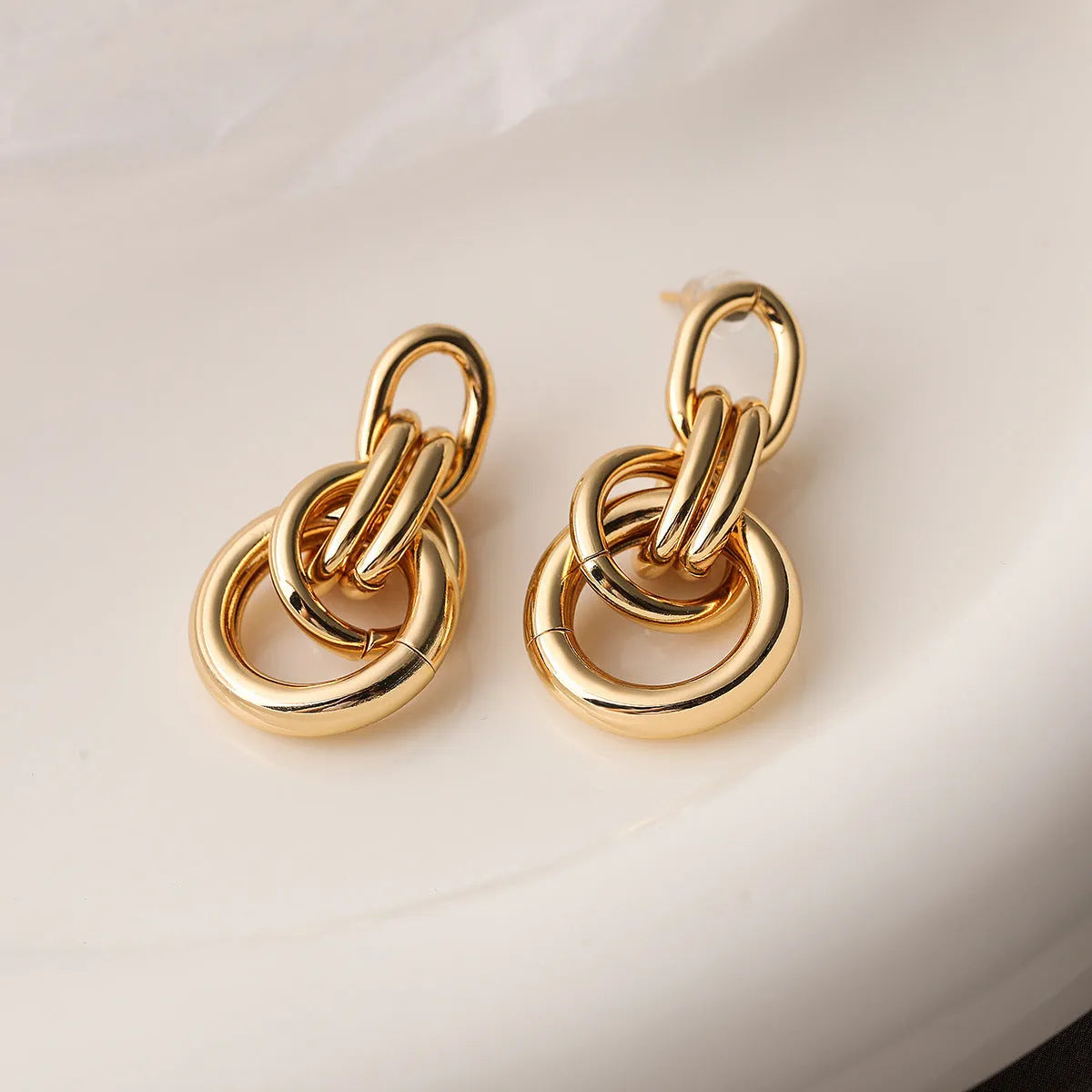 Geometric irregular-shaped copper earrings for women with a real gold colour finish.
