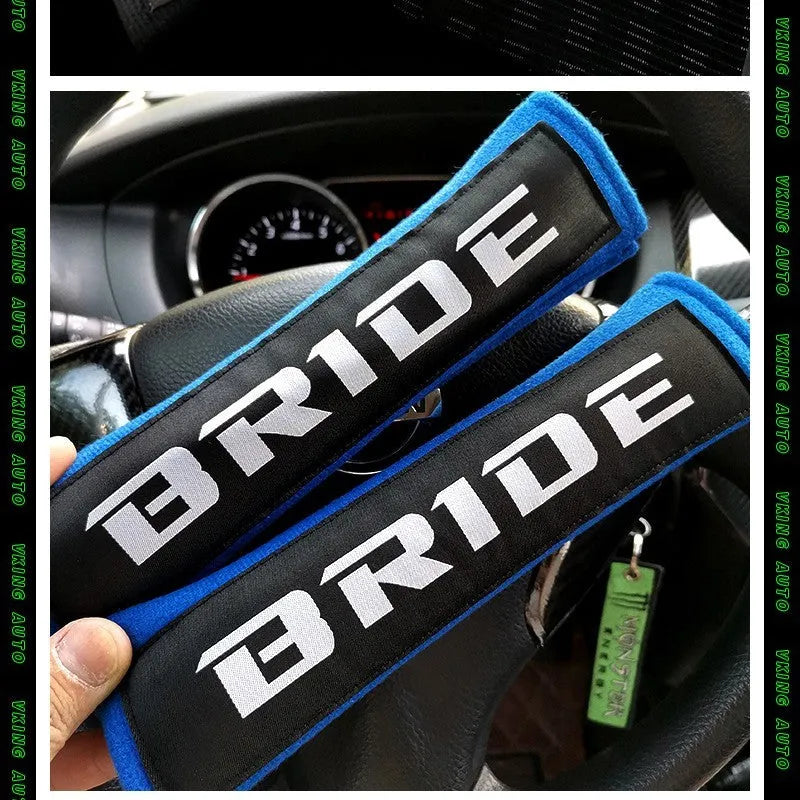 Pair of black car seatbelt shoulder pads with embroidered texture, showing dimensions.
