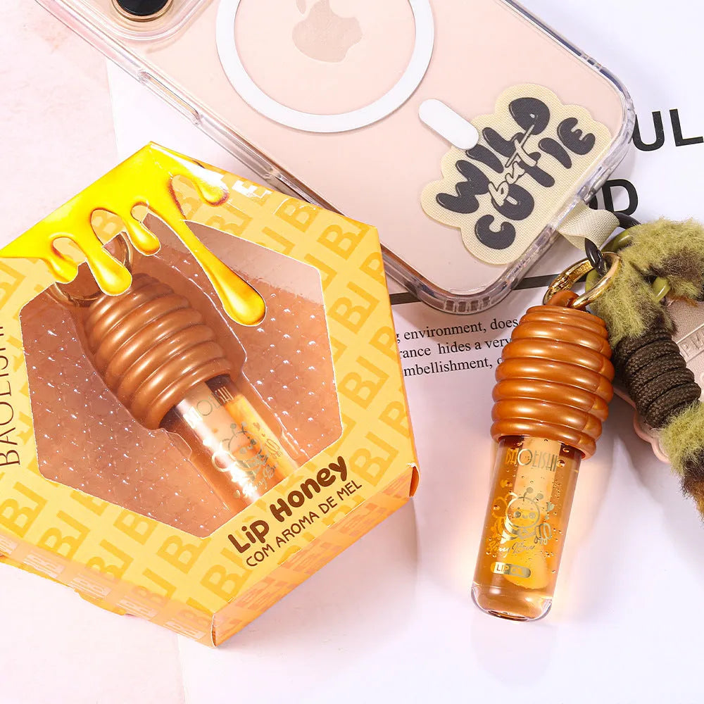 Portable honey lip gloss canister with keychain attachment for moisturising and nourishing lips.