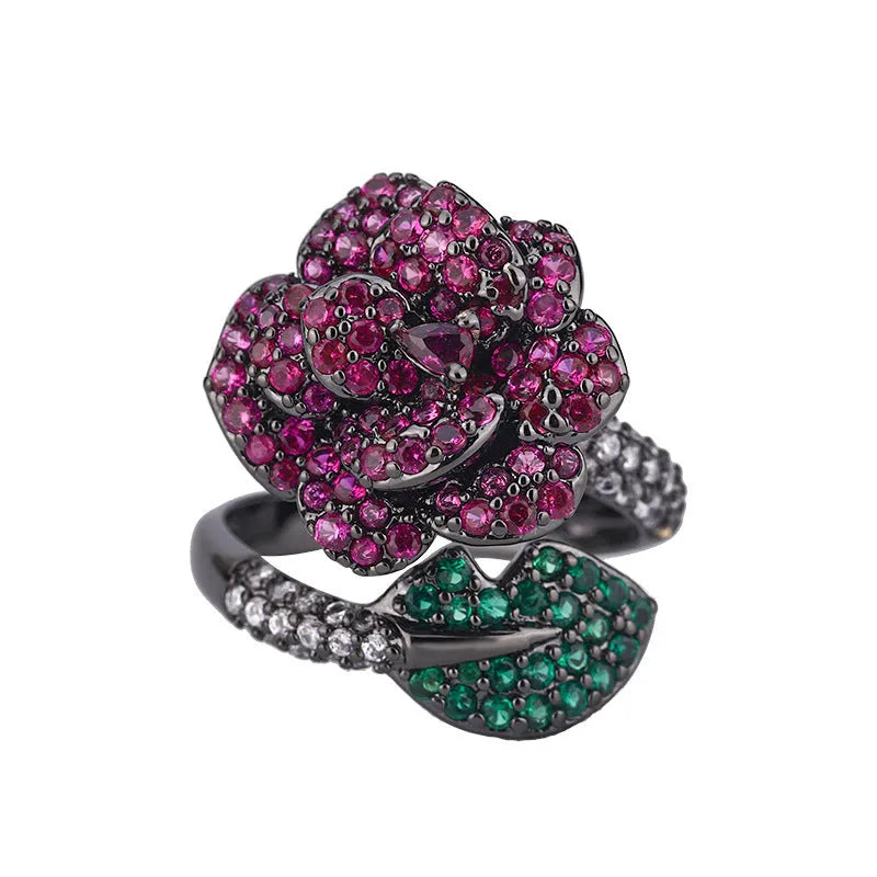 Geometric black gold flower ring with simulation red corundum centrepiece on female hand