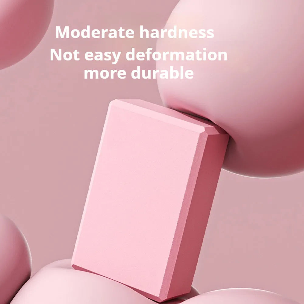 Solid colour high-density EVA foam yoga block with ridged sides on a gym mat