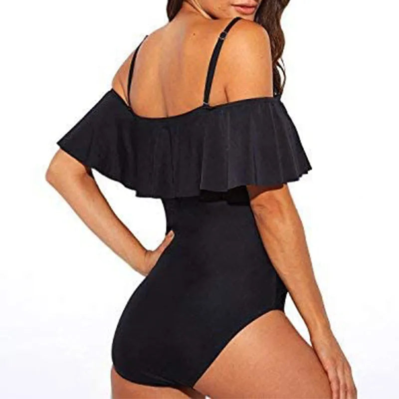 Black women's strapless one-piece swimsuit with a cut-out detail and ruffled strap.