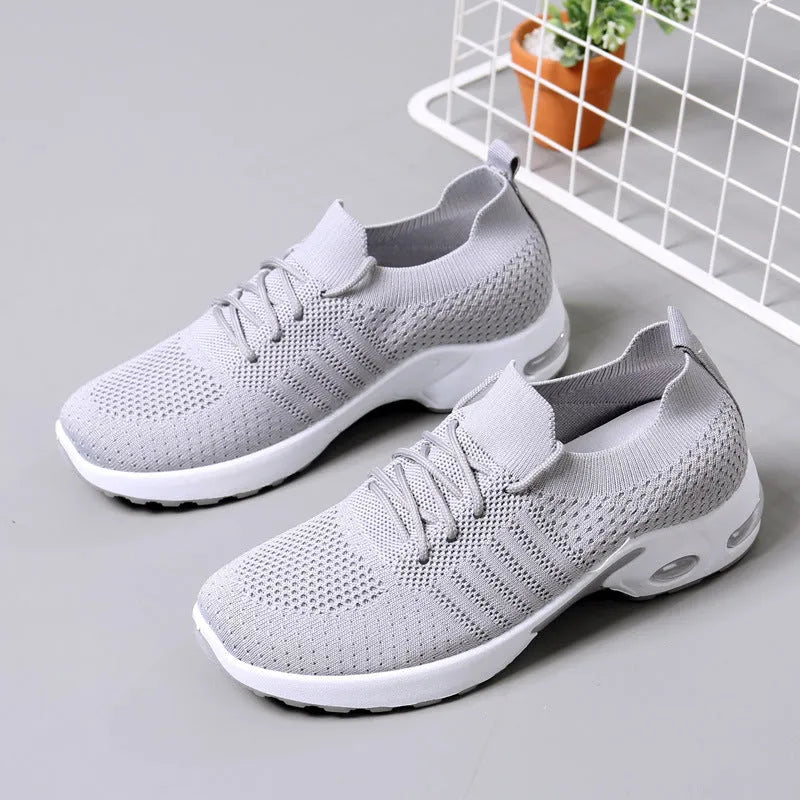Women's black mesh casual sneakers with round toe and white non-slip sole on a grey background.