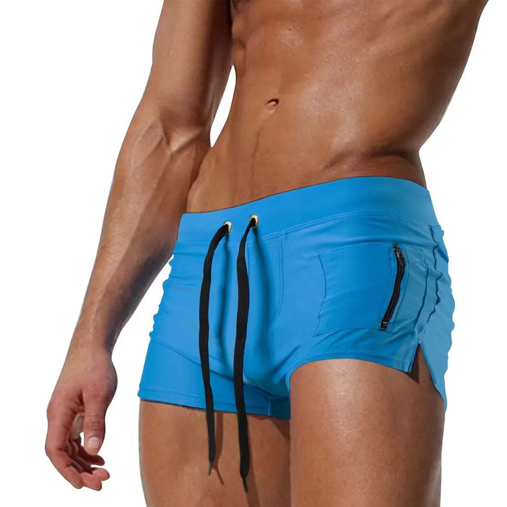 Men's black high-waisted swimming trunks with a white lace-up front detail, laid flat.