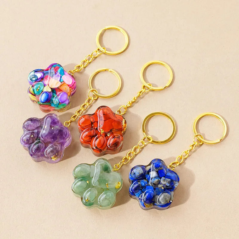 Natural crystal cat's paw shaped pendant on a silver keychain ring, shown in a random colour.