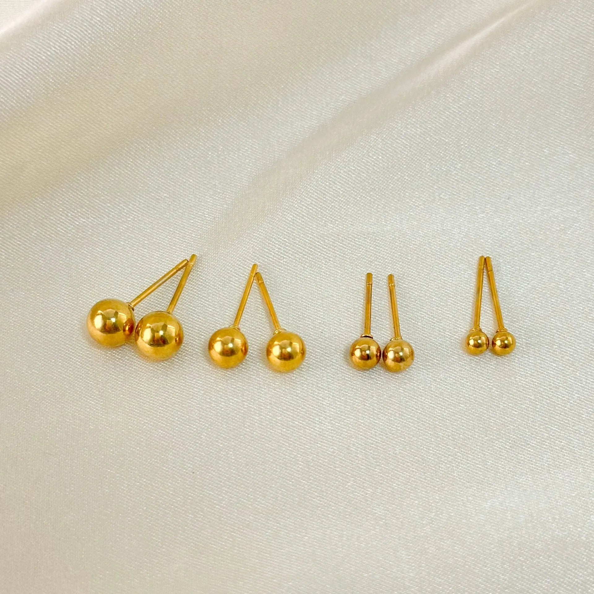 Stainless steel ball stud earrings showing 3mm, 4mm, 5mm, and 6mm sizes with gold and silver finishes