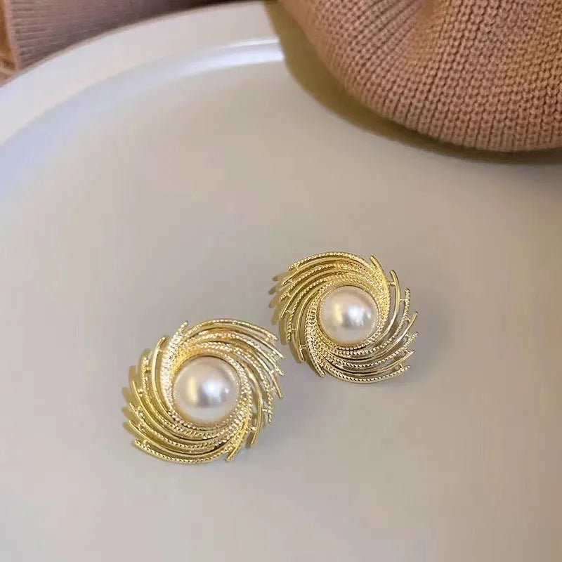 A pair of vintage-style alloy flower earrings with pearl-coloured details and an irregular shape.