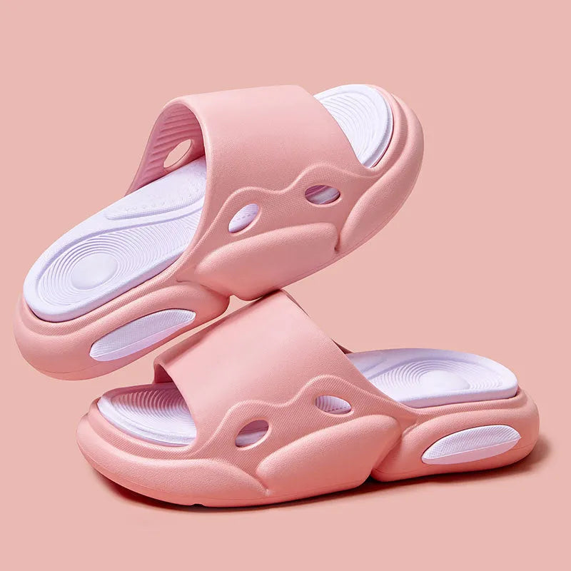 Two-colour EVA slippers for couples in pink and purple, shown on a wooden floor.