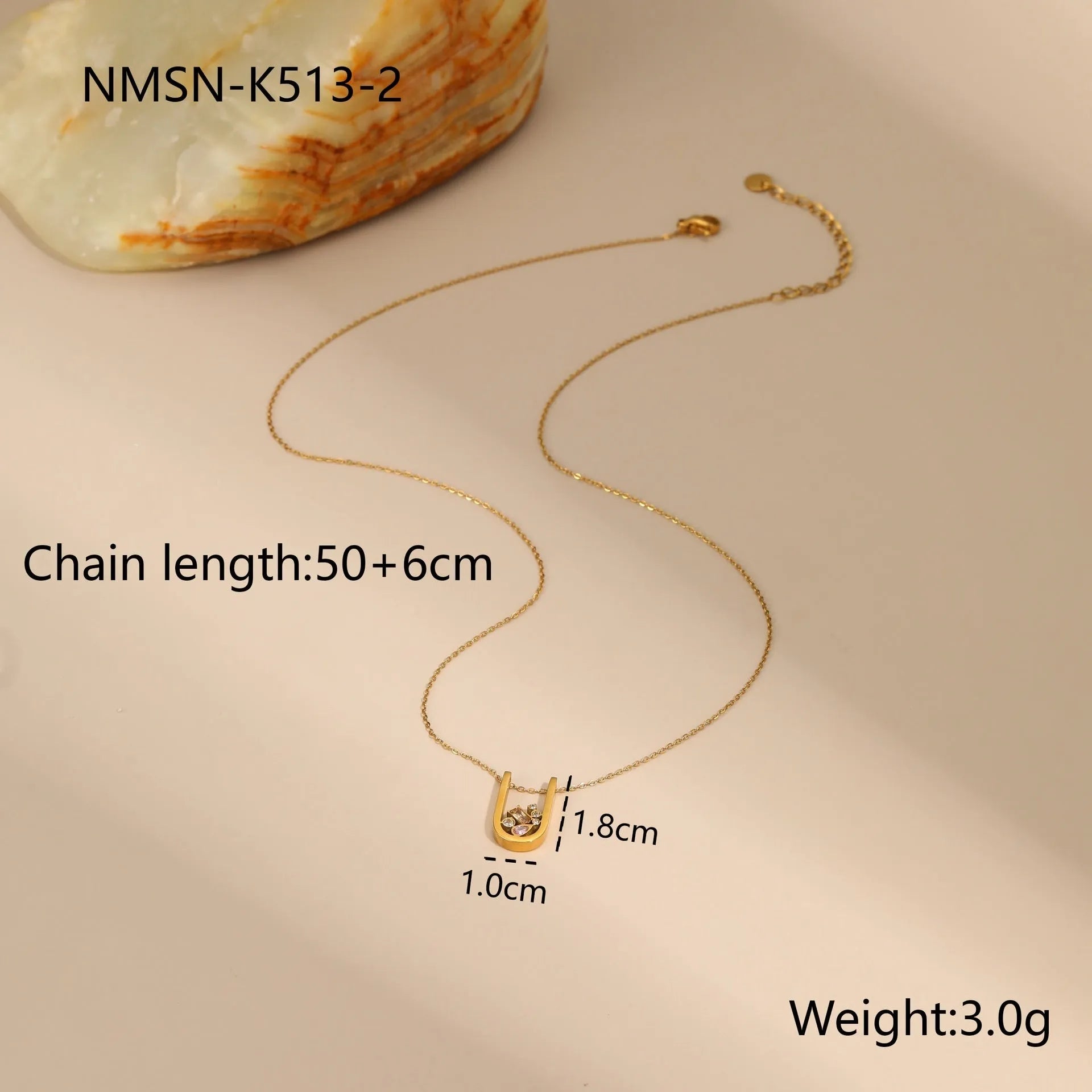 Geometric gold plated jewellery set with colour zircon necklace, ring, and earrings on a white background.