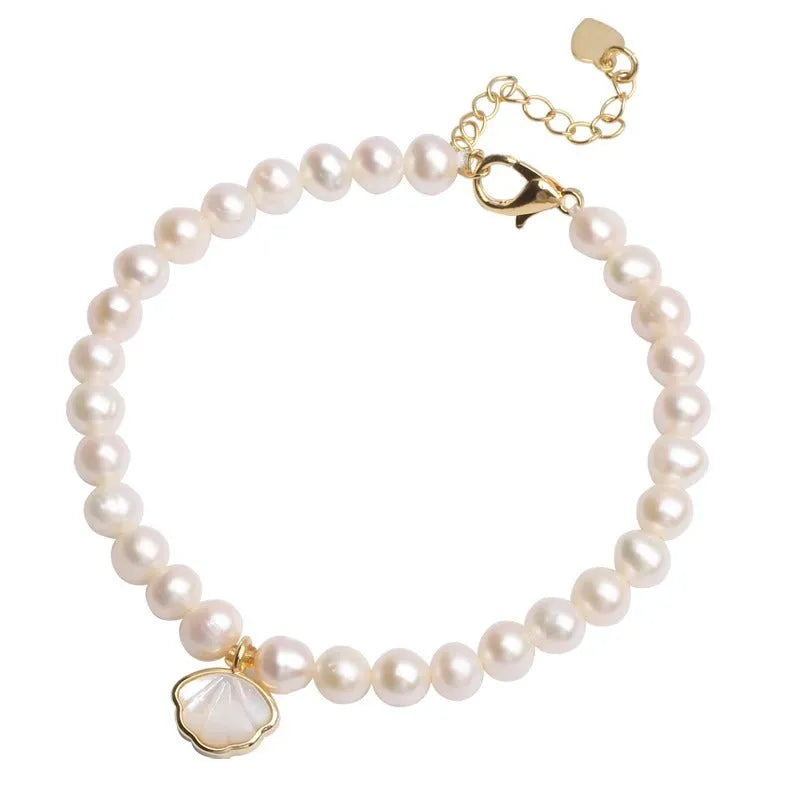 Women's freshwater pearl fan bracelet with alloy shell on wrist, showing elastic and chain closure options.