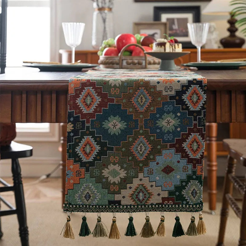 Dark blue Nordic Jacquard table runner with bouquet design and tassels laid on a wooden table.