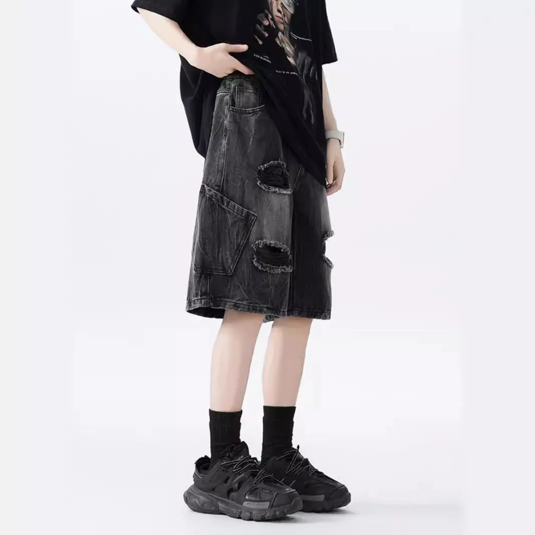 Loose washed blue denim shorts with a ripped knee detail on a mannequin, showing the retro fit.