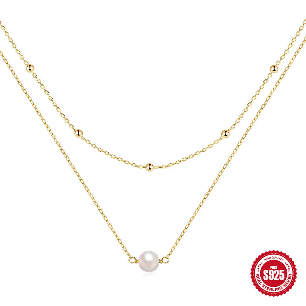 S925 sterling silver double layer necklace with twin pearls on a geometric pendant, shown in gold and white gold finishes.