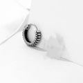 Silver geometric stainless steel earrings with a twist and striped design on a white background.