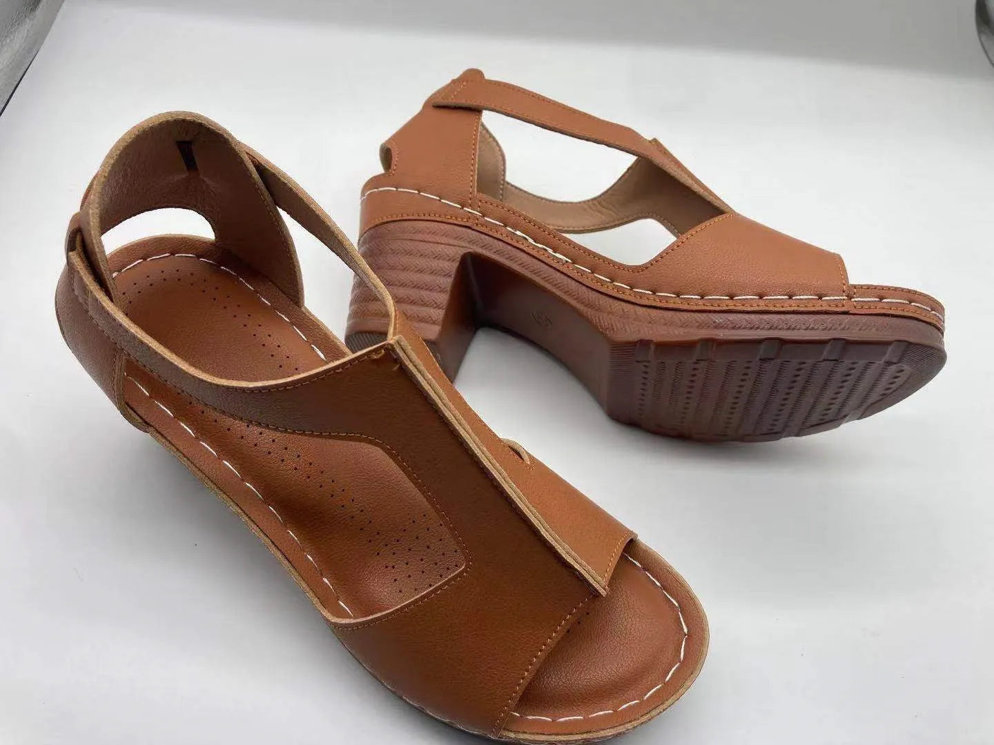 Women's peep toe wedge sandals with a buckle strap, shown in a light brown colour on a white background.