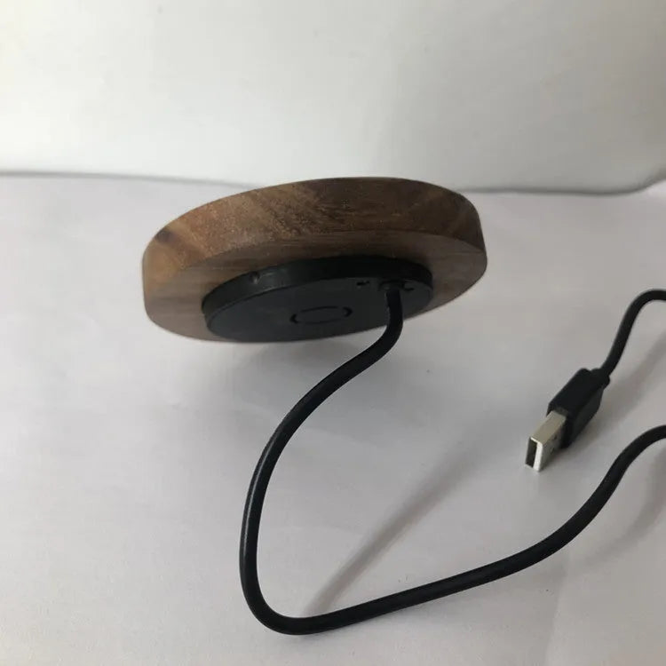 Round hidden wireless charger for embedding in desks, compatible with iPhone and Samsung phones.