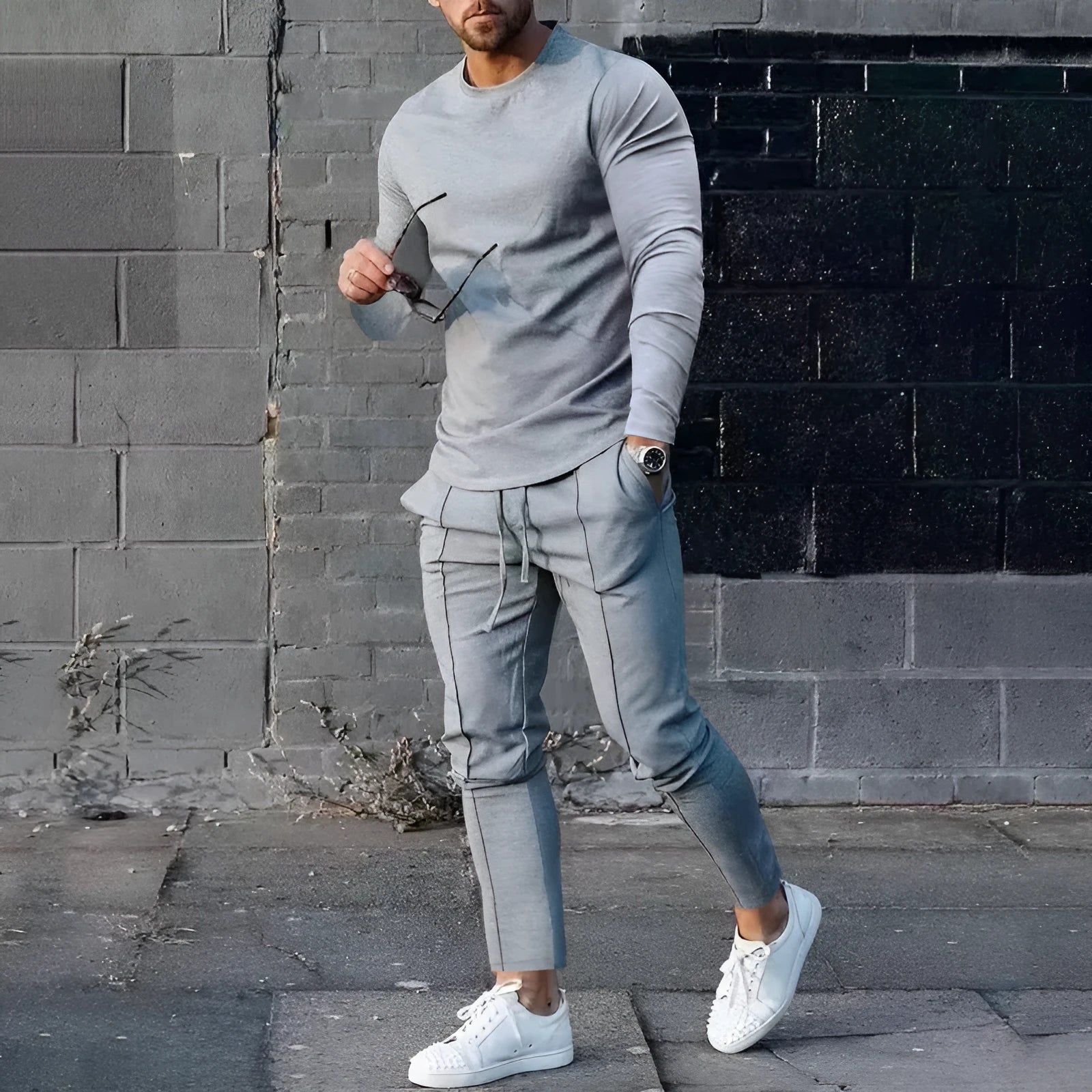 Men's light grey polyester two-piece suit with long sleeve round neck T-shirt and matching trousers laid flat.
