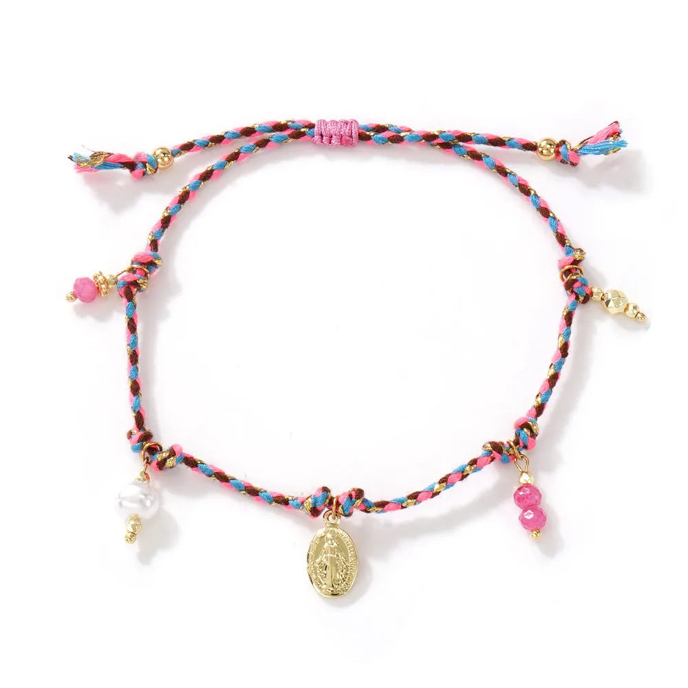 Close-up of a hand-woven colourful braided rope bracelet with a leather closure and strap tag detail.